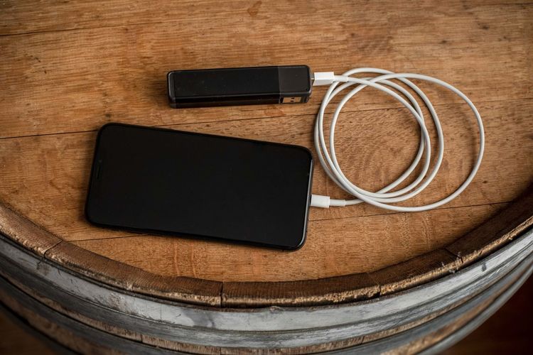 A smartphone charges through a usb battery charger.