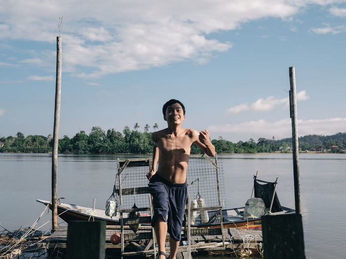 Portrait of young man standing in boat