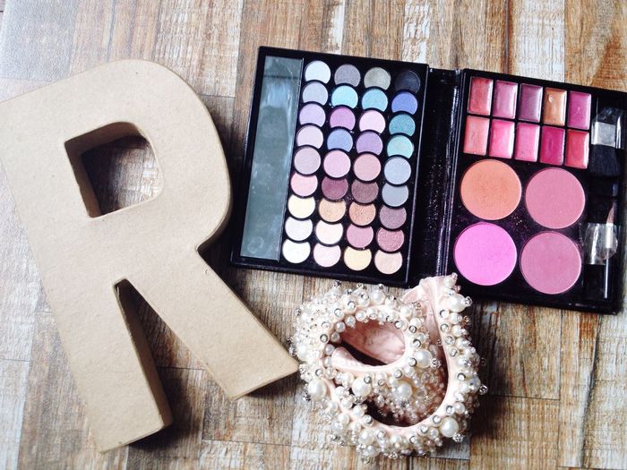 High angle view of letter r with make-up kit on table