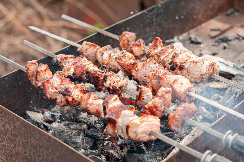 Marinated shashlik preparing on barbecue grill over charcoal. shashlik or shish kebab in europe