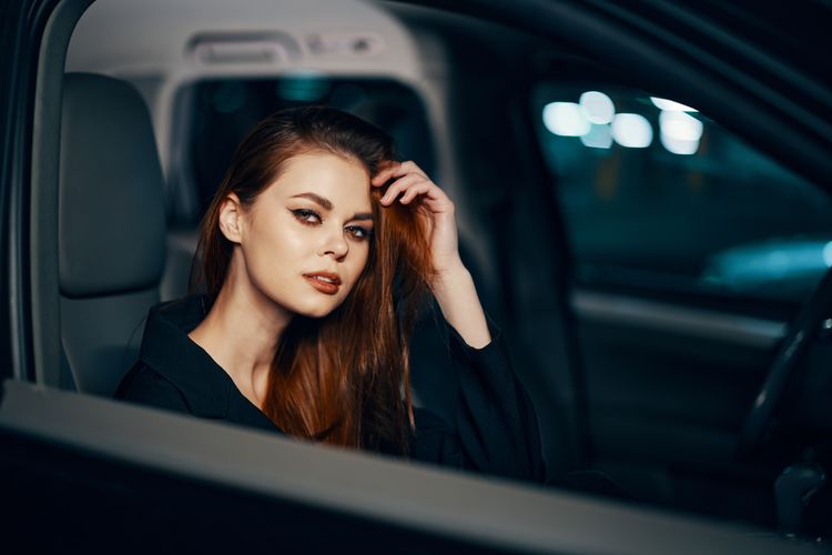 Portrait of young woman sitting in car