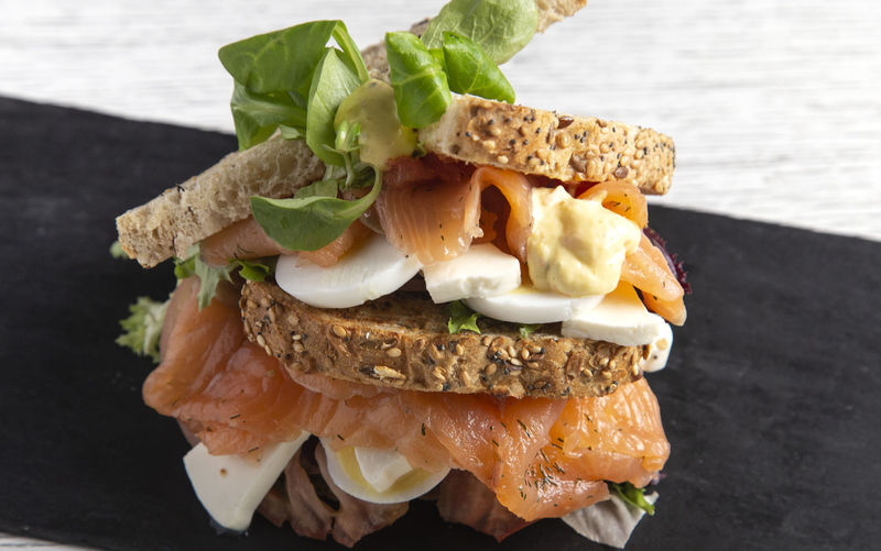 Delicious smoked salmon cereal sandwich with fresh cheeseseed bread and cereals. isolated image