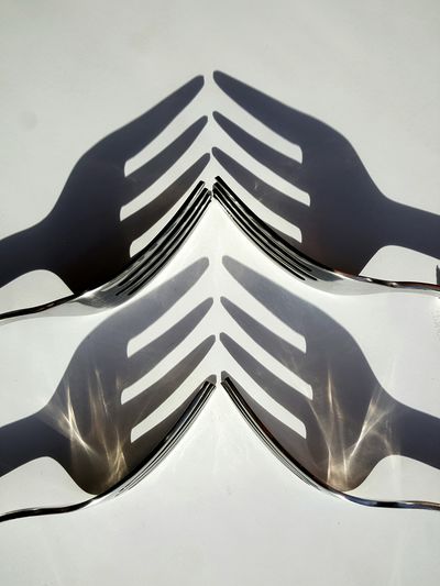 Close-up of forks with shadow on table