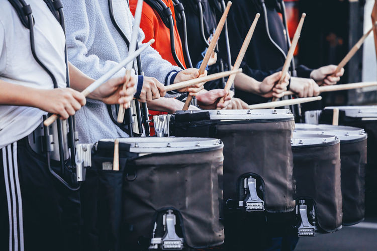 A section of a marching band drum line warming up before rehearsal