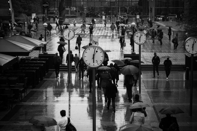 High angle view of people walking on wet street during rainy season in city