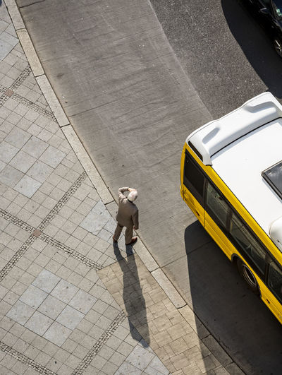 High angle view of man standing on sidewalk in city