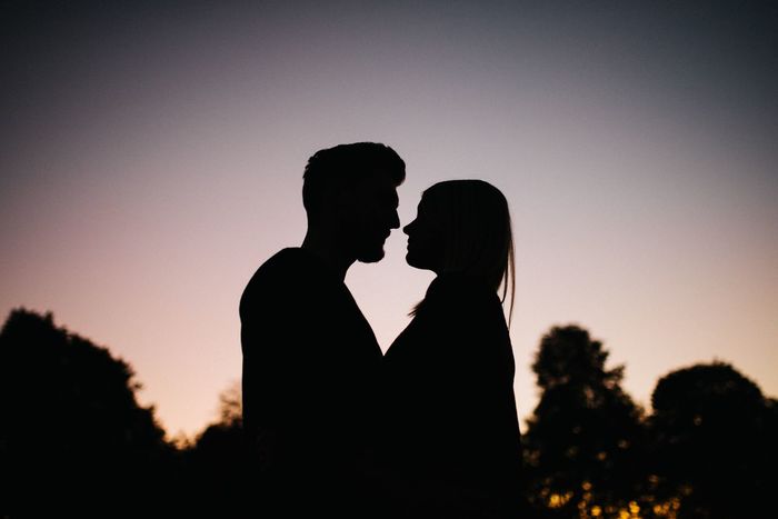 Side view of silhouette couple standing against sky during sunset