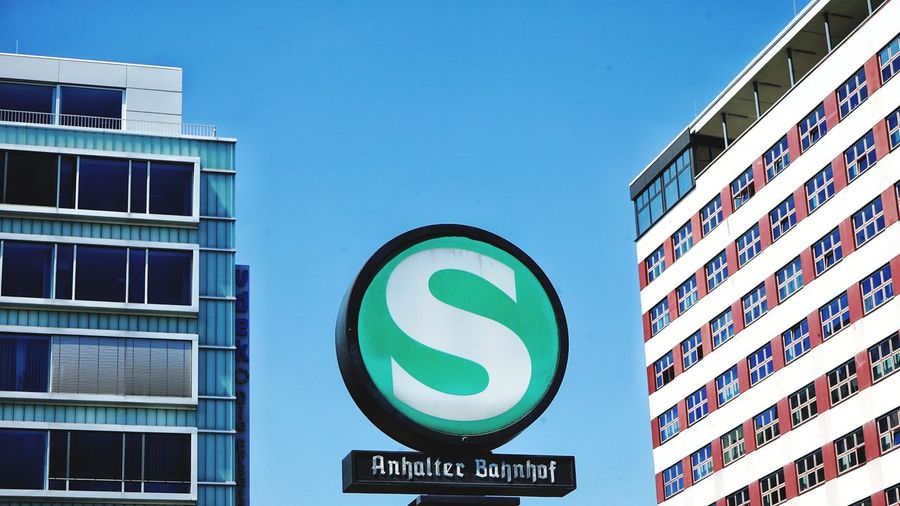 Low angle view of road sign against buildings in city