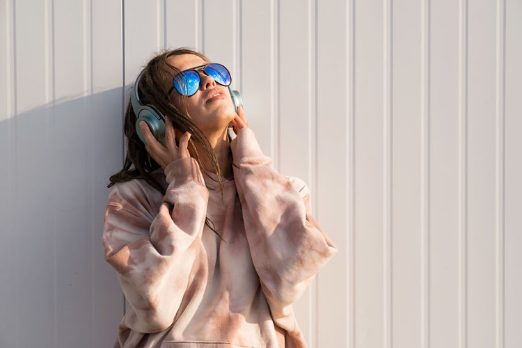 Dreadlock woman listening to music in headphones.