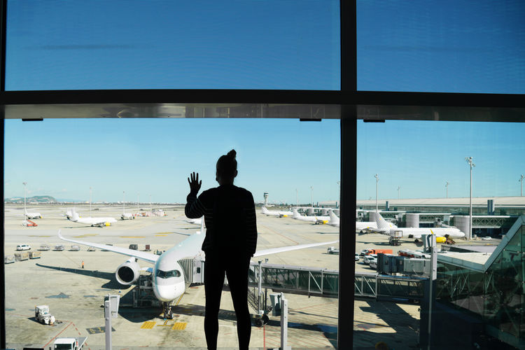 Woman standing by the window at the airport