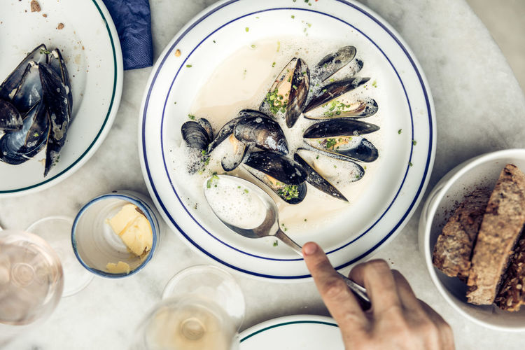 Cropped hand having clams on table
