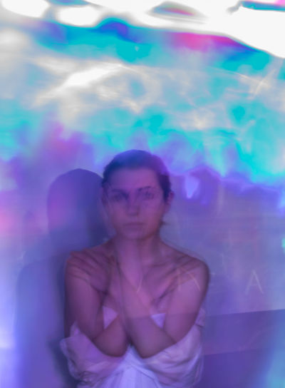 Multiple exposure of young woman in multi colored glass room