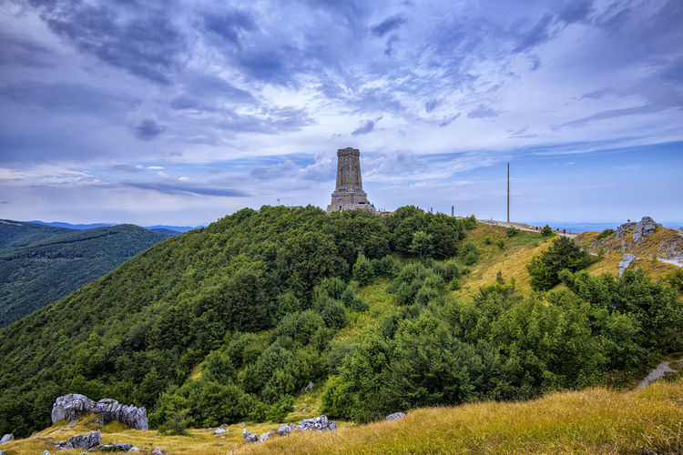 Scenic view of trees and shipka monument against sky