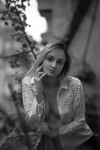 Portrait of woman in fully unbuttoned shirt outdoors