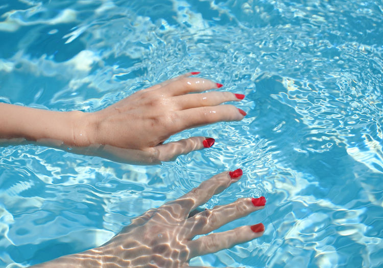 Close-up of woman hands in swimming pool