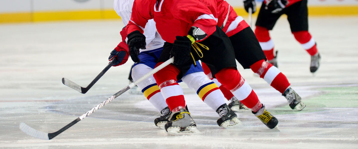Low section of people playing ice hockey