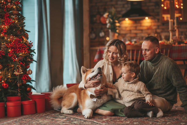 Candid authentic happy family during wintertime together enjoying holidays with dog at xmas