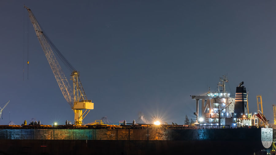 Container oil ship repair in shipyard at night. can use for shipping or transportation concept.