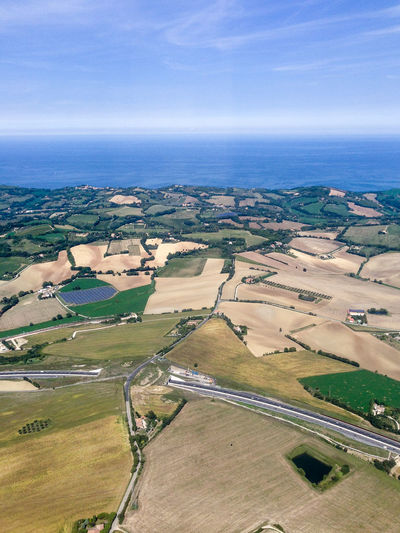High angle view of sea by landscape against sky
