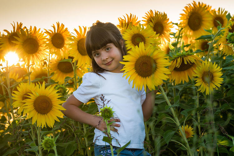 Portrait of girl standing on sunflower