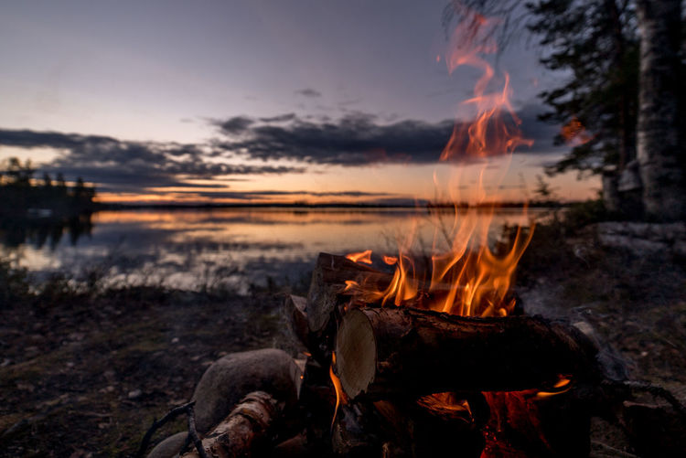 Bonfire at lakeshore during sunset