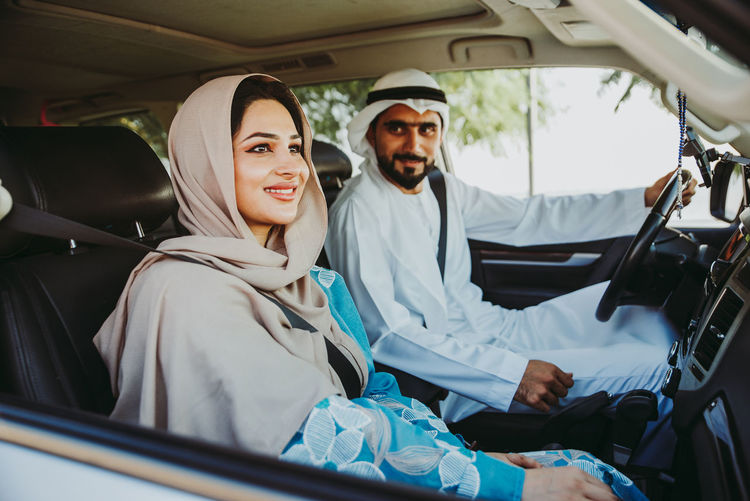 Couple wearing traditional clothing sitting in car