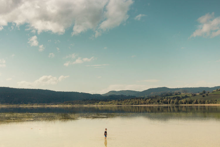 Child alone on the shores of lake remoray in the doubs department
