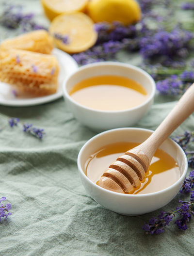Bowls of honey, honeycomb and lavender flowers
