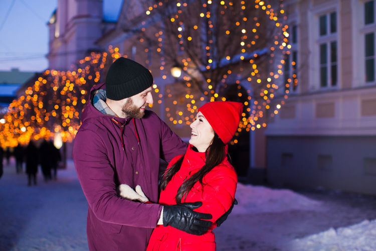 Cheerful couple embracing outdoors during winter