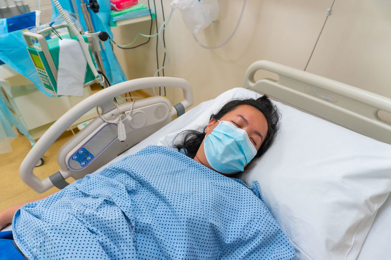 High angle view of woman lying on bed in hospital