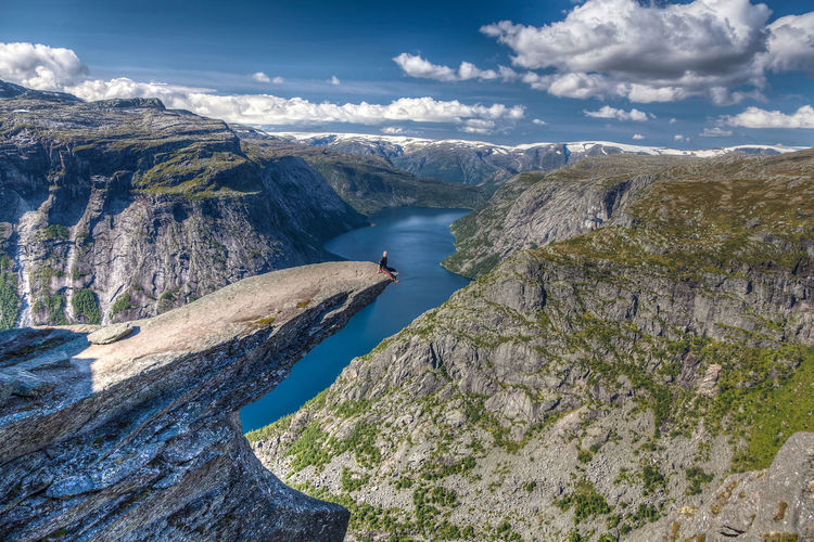 Scenic view of fjord by mountains against sky