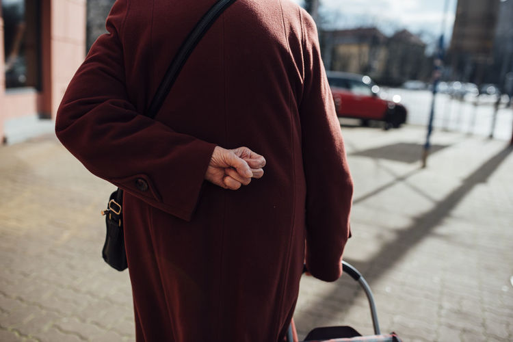 Rear view midsection of woman in warm clothing walking on sidewalk