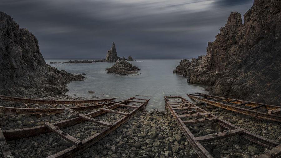 Panoramic view of railroad tracks by sea against sky