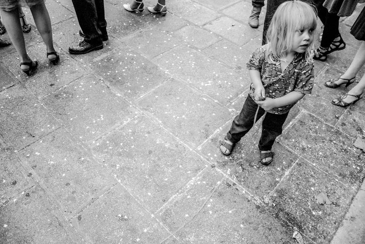 High angle view of girl standing on paved sidewalk