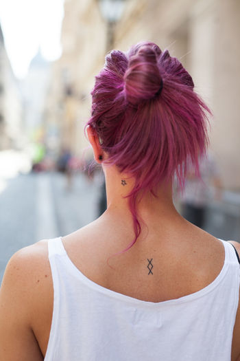 Rear view of woman with purple hair standing outdoors