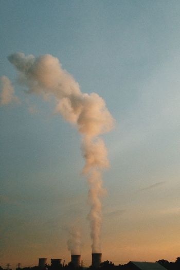 Smoke emitting from chimney against sky