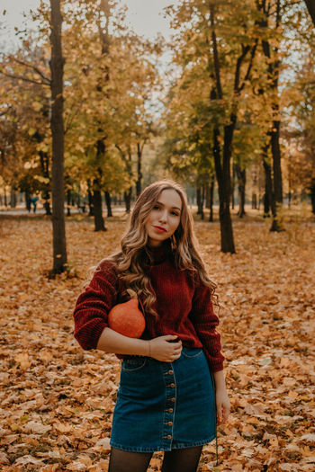 Beautiful young woman standing in park during autumn