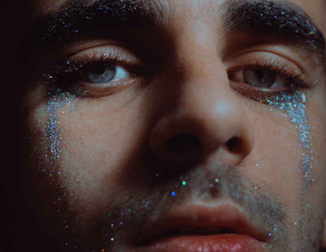 Close-up portrait of man with glitter on facer