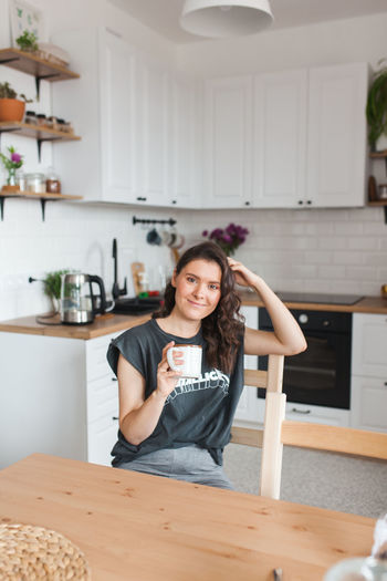 Portrait of smiling woman sitting at home