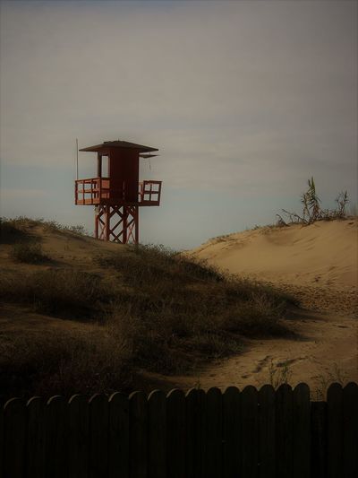 Lifeguard hut on land against sky