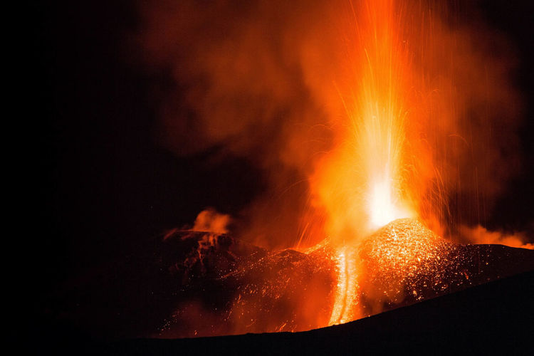 Etna volcano eruption with lava flow and great explosion from top crater at night- sicily adventures
