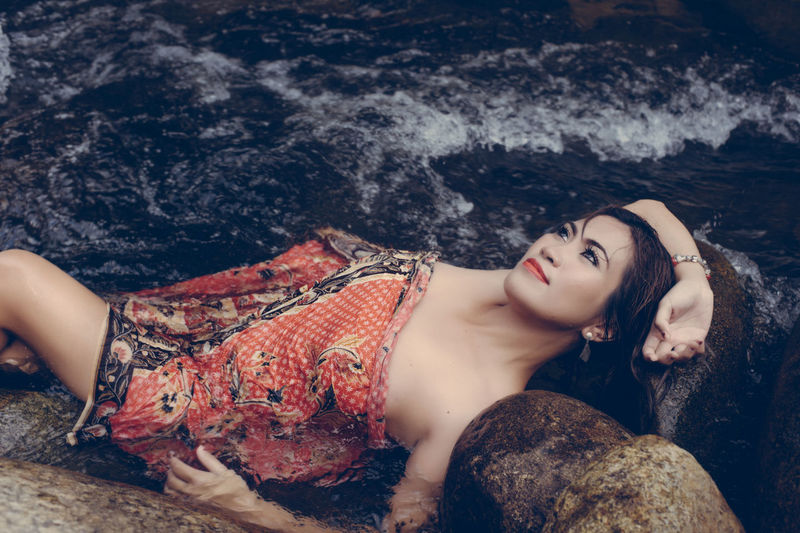 Portrait of woman lying in river