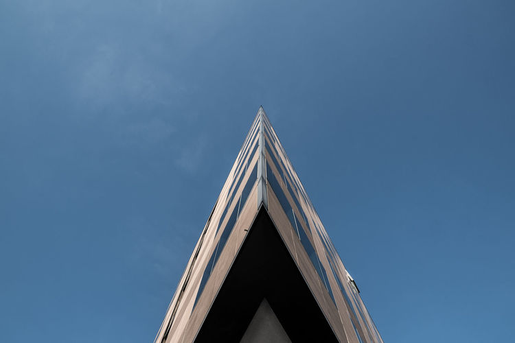 Low angle view of modern building against blue sky