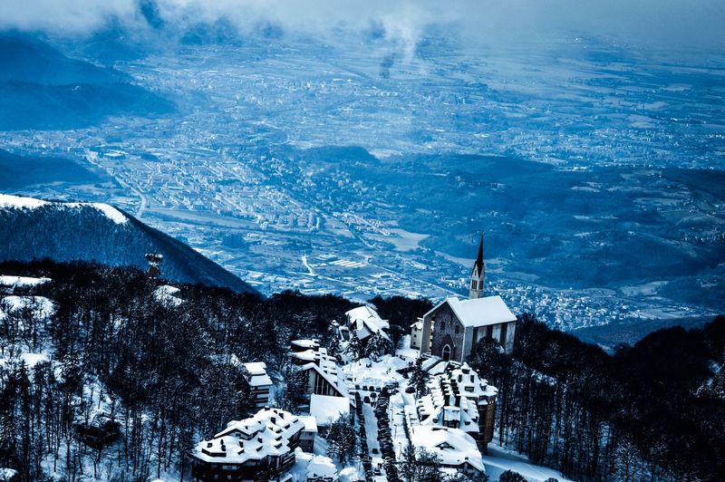 Aerial view of snow covered houses on mountains