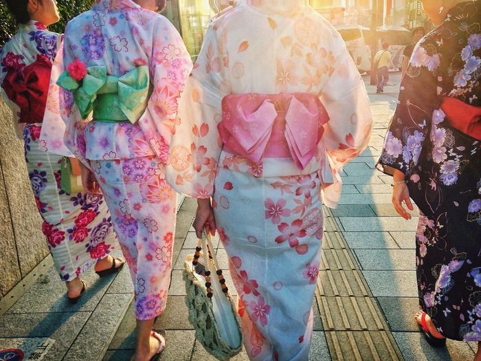 Rear view of women wearing kimono on footpath