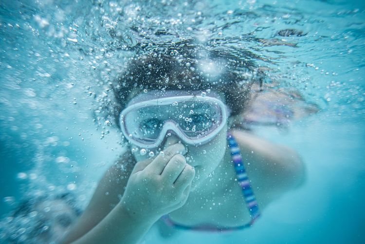 Girl wearing goggles underwater 