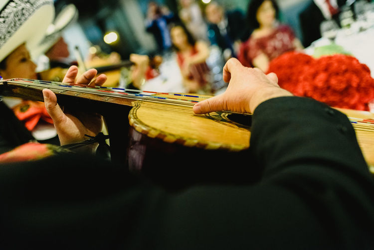 Midsection of man playing string instrument during celebration