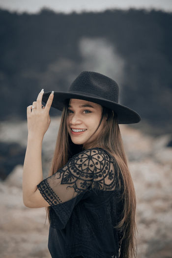 Portrait of smiling young woman wearing hat