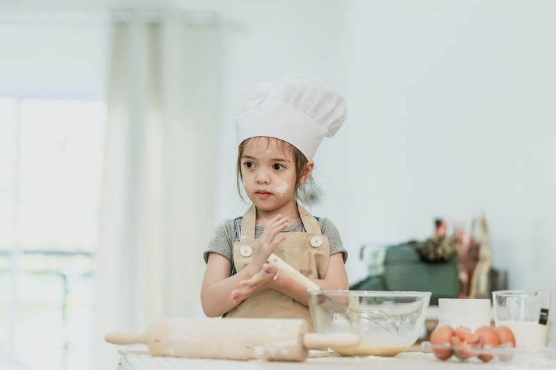 Portrait of a girl having food in kitchen