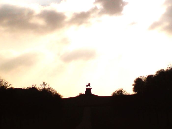 Silhouette of statue against cloudy sky